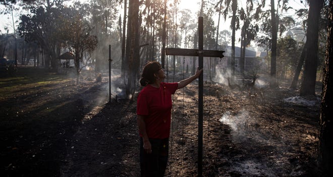 Leslie Accilio looks over her damaged yard along Wilson Boulevard in Golden Gate in Collier County on Saturday, March 4, 2023.  A brush fire ripped through the area on Friday evening. Her house survived the fire but the family she rents to lost a boat and vehicles. Two sheds were also destroyed.  