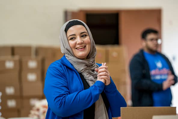 Dima Akach with Islamic Relief USA, greets volunteers at Al-Ghazaly High School in Wayne, NJ on Saturday, March 4, 2023 to pack boxes of food to combat food insecurity.