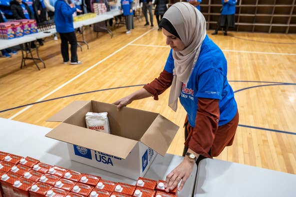 Frances Aboushi demonstrates how to pack a box for Islamic Relief USA at Al-Ghazaly High School in Wayne, NJ on Saturday, March 4, 2023. The boxes of food will be distributed to combat food insecurity.