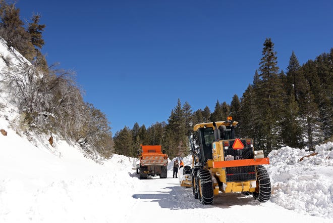 Caltrans workers try to clear avalanche debris from California State Route 38 after a series of snowstorms on March 2, 2023, near Big Bear, California. San Bernardino County has declared a state of emergency as communities remain buried after a series of blizzards shut down all roads into the mountains, leaving the area running low on gas, food and supplies.