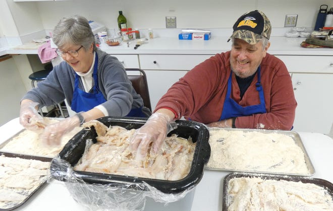 Tressa and Bob Reith bread pieces of fish during the Knights of Columbus fish fry at Crestline St. Joseph School on Friday. Meals will be served every Friday through March 31.