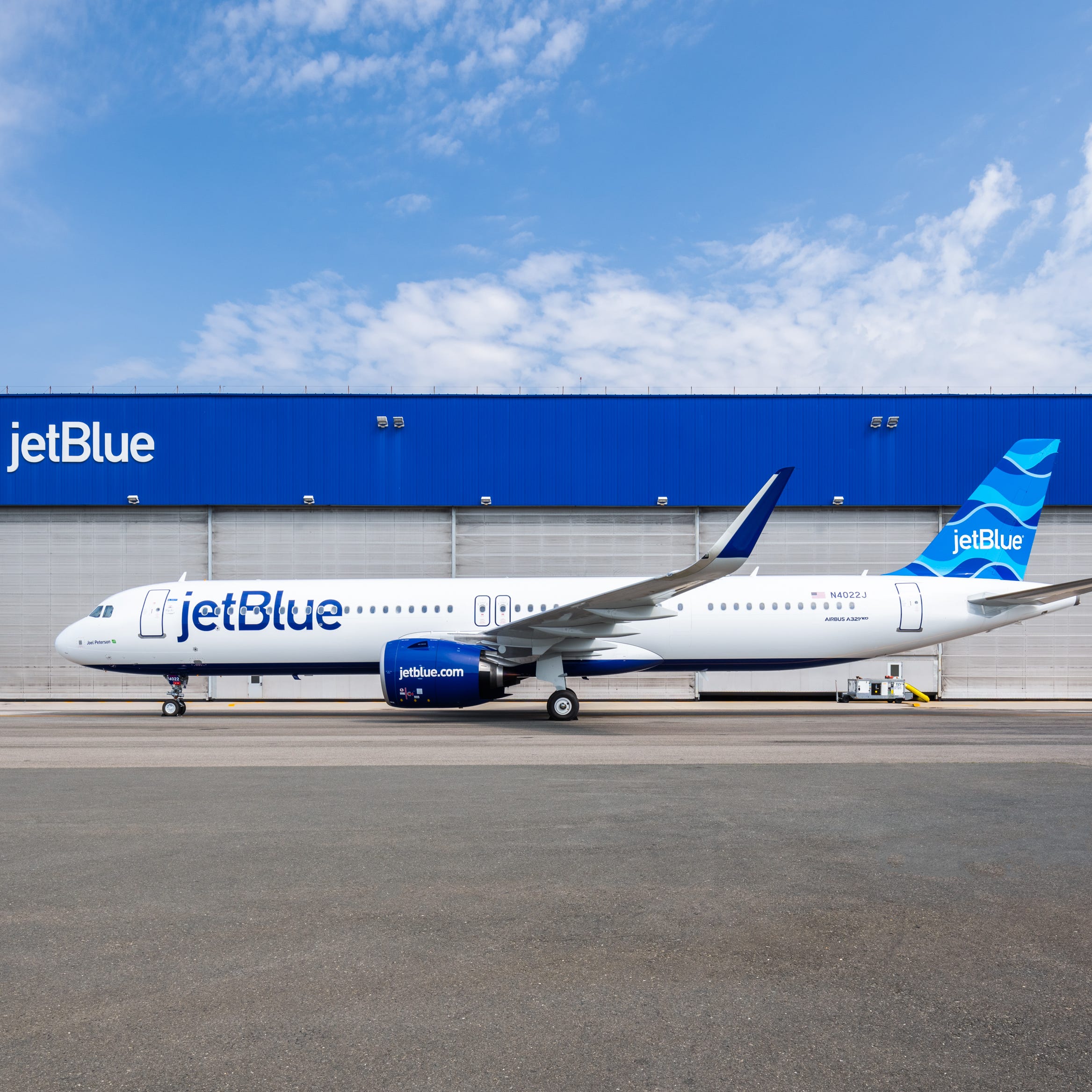 A JetBlue Airbus A321LR outside of one of the airline's hangars.