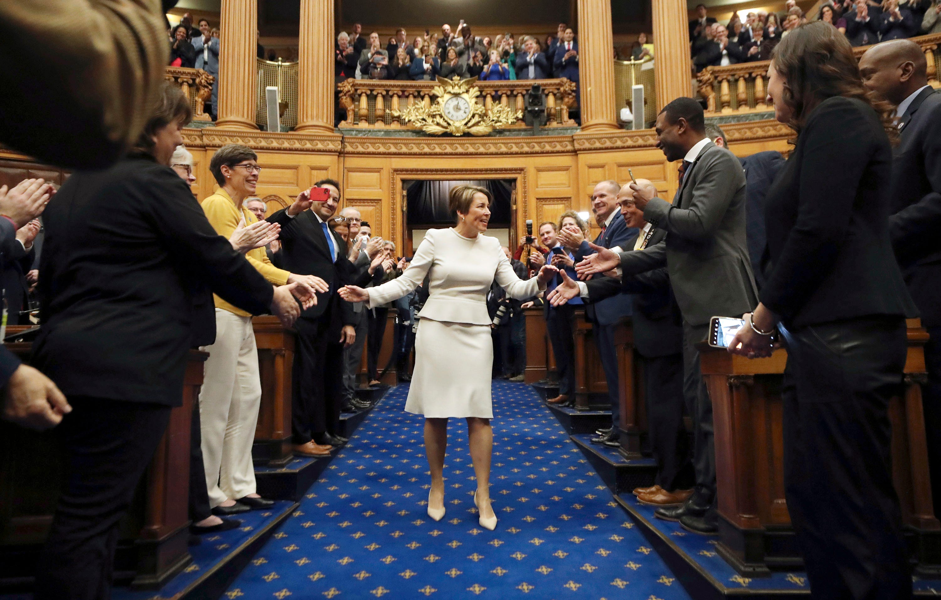 Massachusetts Gov.-elect Maura Healey shakes hands as she arrives in the House chambers to be sworn in as governor, Thursday, Jan. 5, 2023, at the State House in Boston.