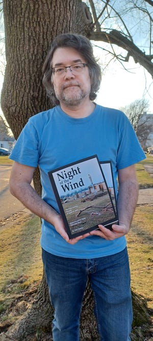 Dan Cherry holds two copies of his revised edition of "Night of the Wind," which brings together the memories of more than 100 survivors and photographs of the 1965 Palm Sunday tornado.