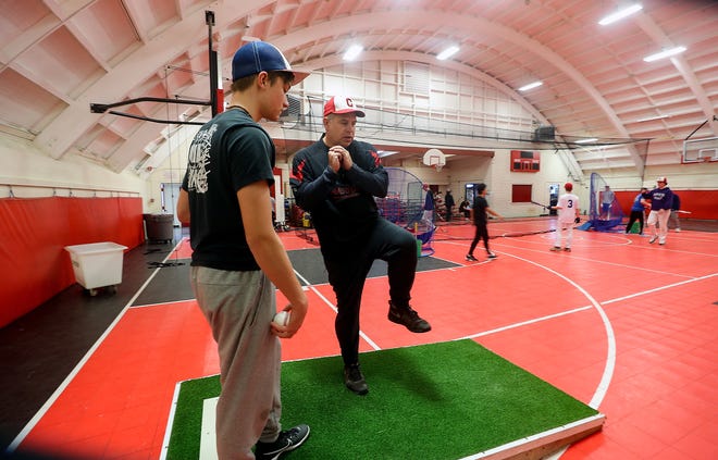 Crosspoint head coach Derrin Doty demonstrates a pitching delivery as he works with prospective bullpen addition Levi Bates during practice in the school’s gym on Wednesday, March 8, 2023.