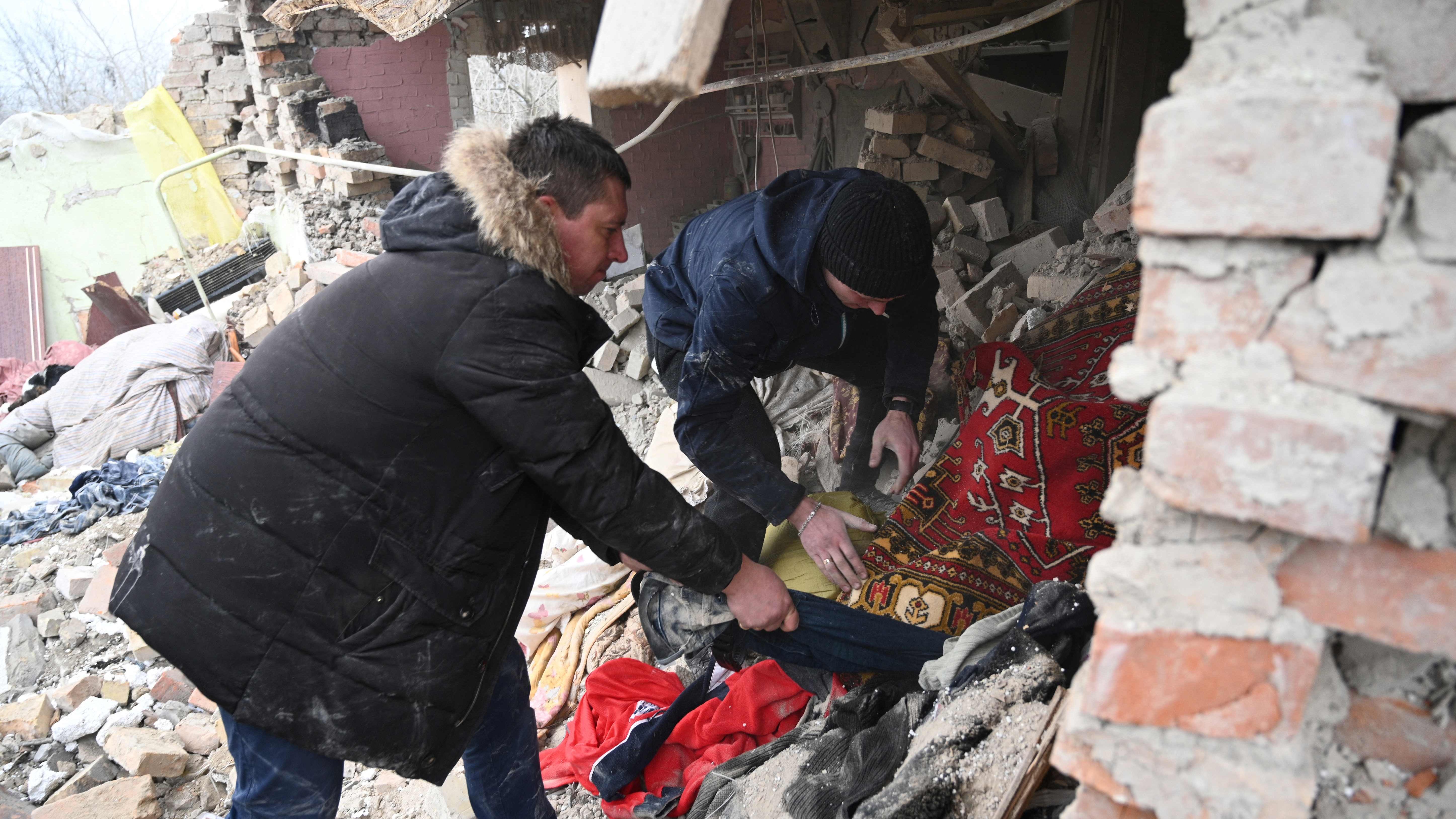 People search the rubble of a house following a Russian strike in the village of Velyka Vilshanytsia, near Lviv, on March 9, 2023.