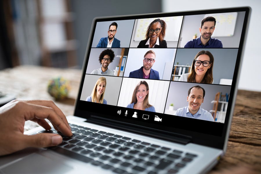 a laptop on a table with a Zoom meeting up and nine attendees other than the person at the computer