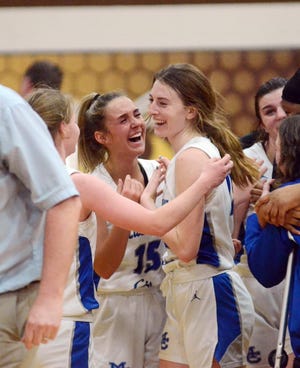 Mackinaw City's Marlie Postula (middle) and Larissa Huffman (right) celebrate, with teammate Gracie Beauchamp (left) coming in for a hug following their regional championship victory over Inland Lakes in Pellston on Thursday.