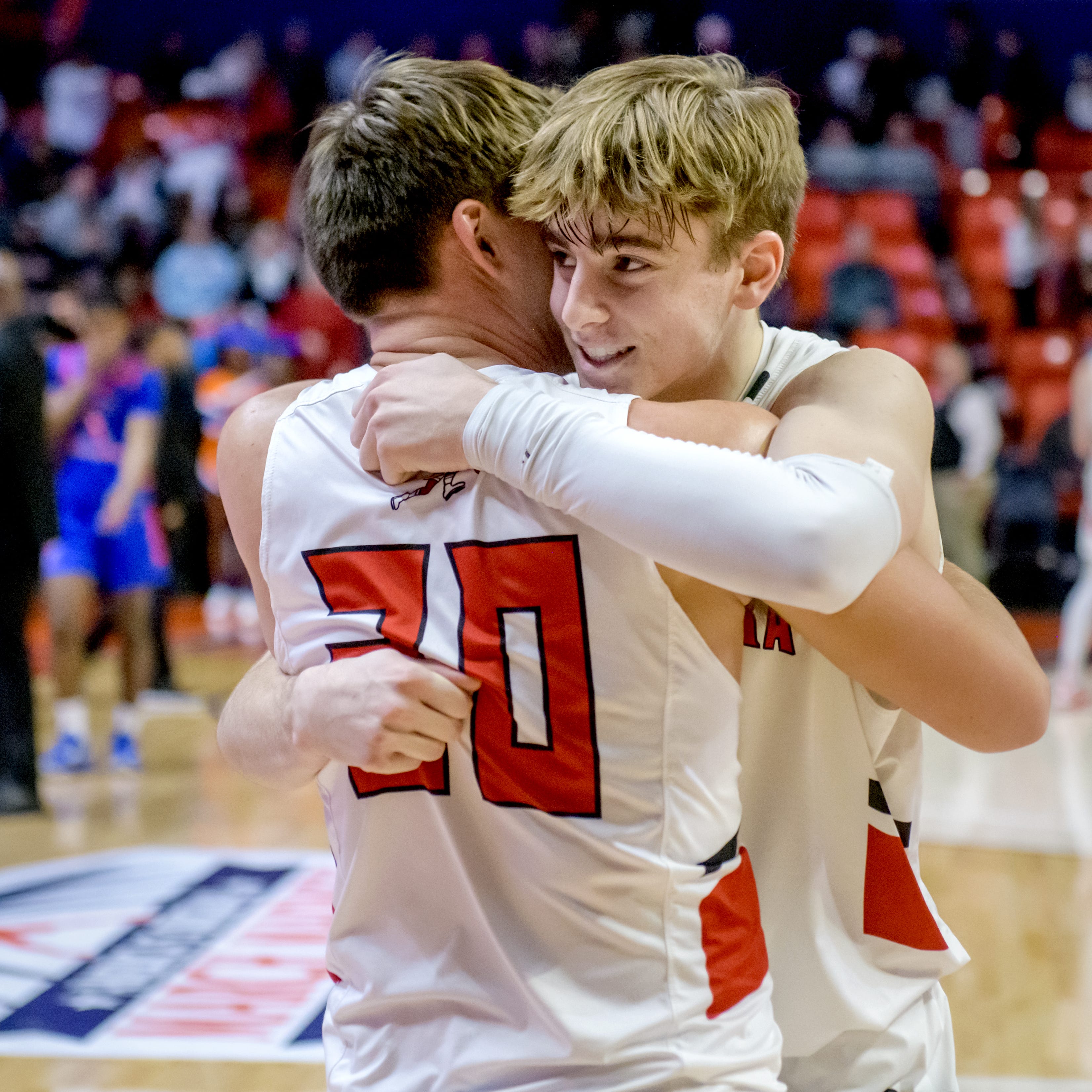 Metamora's Tyson Swanson, facing, and teammate Briar Cremeens embrace after the Redbirds' 50-43 victory over East St. Louis in the Class 3A state semifinal game Friday, March 10, 2023 at State Farm Center in Champaign.