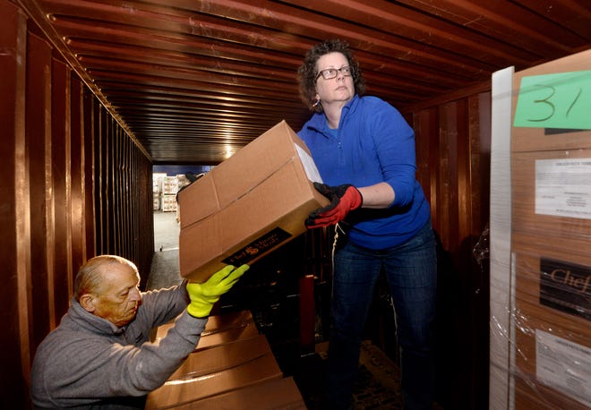 Inventory specialist Sarah Frazee, right, and Chatham operations manager Brad Walton stack boxes of donations into a truck for earthquake victims in Turkey at the Midwest Distribution Center Friday.
