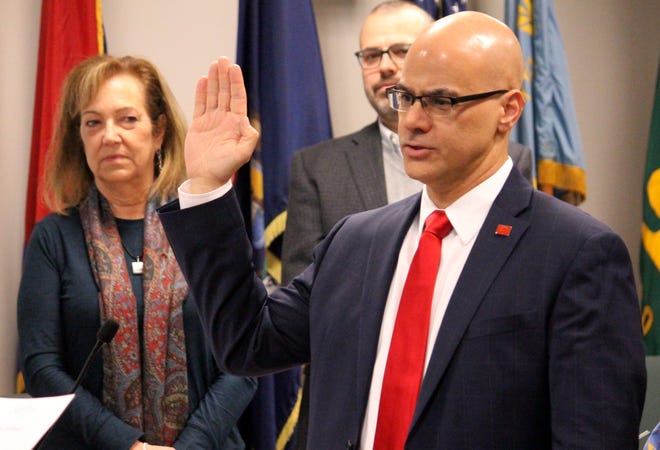 George Lahanas is sworn in as Northville's next city manager during a city council meeting March 6 as council members Barbara Moroski-Browne and John Carter look on in the background.
