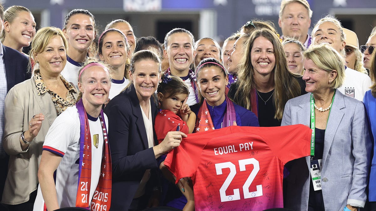 Members of U.S. Soccer, the U.S. Women's National Team Players Association and other dignitaries pose for a photo after signing a collective bargaining agreement signifying equal pay between the men's and women's national soccer teams at Audi Field on Sep. 6, 2022 in Washington, D.C.