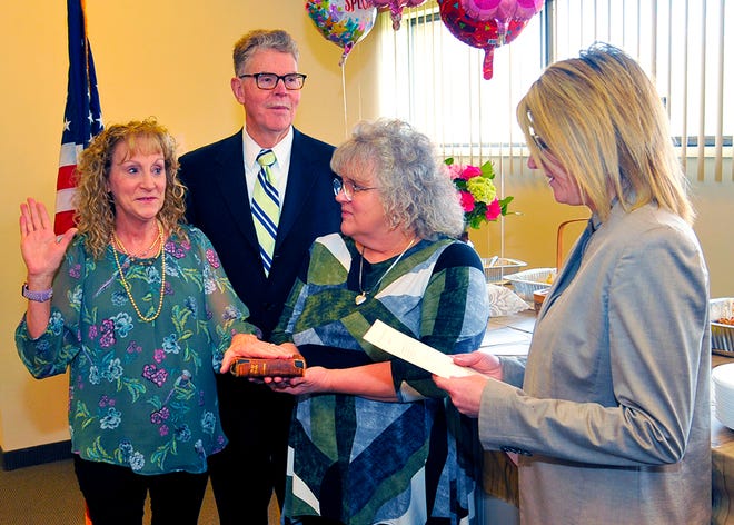 Barbara Biro, right, chief civil assistant prosecuting attorney, swears in Jarra Underwood, left, for her seventh term as Wayne County Auditor while her husband, magistrate Martin Frantz, looks on and Chief Deputy Auditor Keely Zemrock holds a 100-year-old bible that was owned by Underwood’s grandfather.