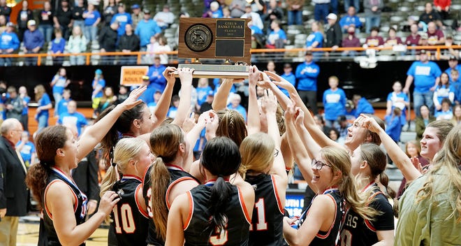 Viborg-Hurley players hold up the championship trophy after the Cougars repeated as the state Class B girls basketball champions with a 71-61 win over Wall on Saturday, March 11, 2023 in the Huron Arena.