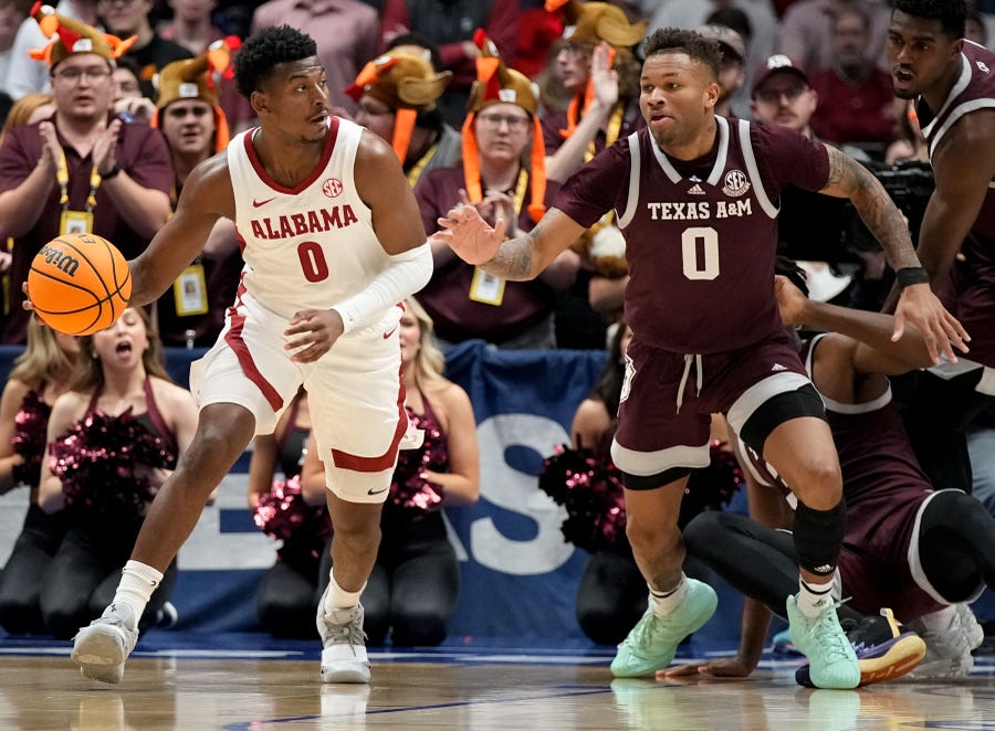Alabama guard Jaden Bradley (0) moves the ball while defended by Texas A&M guard Dexter Dennis (0) during the championship SEC Men's Basketball Tournament game at Bridgestone Arena Sunday, March 12, 2023, in Nashville, Tenn. 