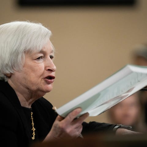 U.S. Treasury Secretary Janet Yellen holds up a co