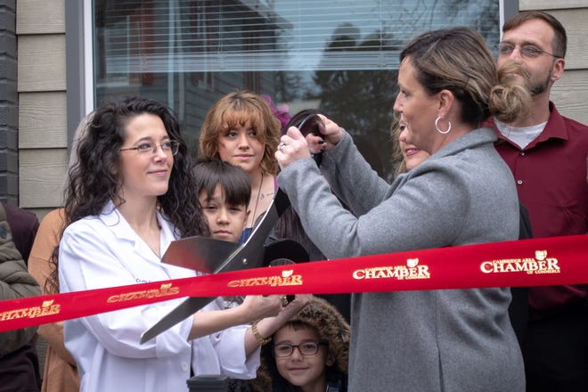 Elisha Clark (left), certified nurse practitioner, gets ready to cut the Cambridge Area Chamber of Commerce ribbon with Chamber President Jennifer Vincent at Clark Family Practice in Byesville.