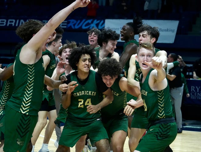 Hendricken players surround guard Azmar Abdullah as they celebrate their 67-61 victory over La Salle on Sunday evening in the state boys basketball championship game.