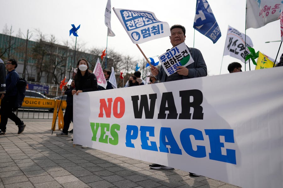 FILE - Protesters hold signs during a rally to oppose to the planned the joint military exercises between the U.S. and South Korea, in Seoul, South Korea, Saturday, March 11, 2023. North Korea said Monday, March 13, 2023, it test-fired two cruise missiles from a submarine off its east coast, the latest in the country's series of weapons tests. The test on Sunday came a day before the U.S. and South Korean militaries begin large-scale joint military drills that North Korea views as a rehearsal for   invasion. (AP Photo/Lee Jin-man, File)