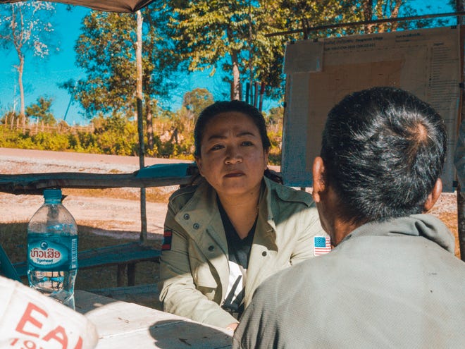 Sera Koulabdara, chair of the US Campaign to Ban Landmines and the Cluster Munition Coalition, speaks with cluster bomb survivor Yong Kham in southern Laos in November 2022.