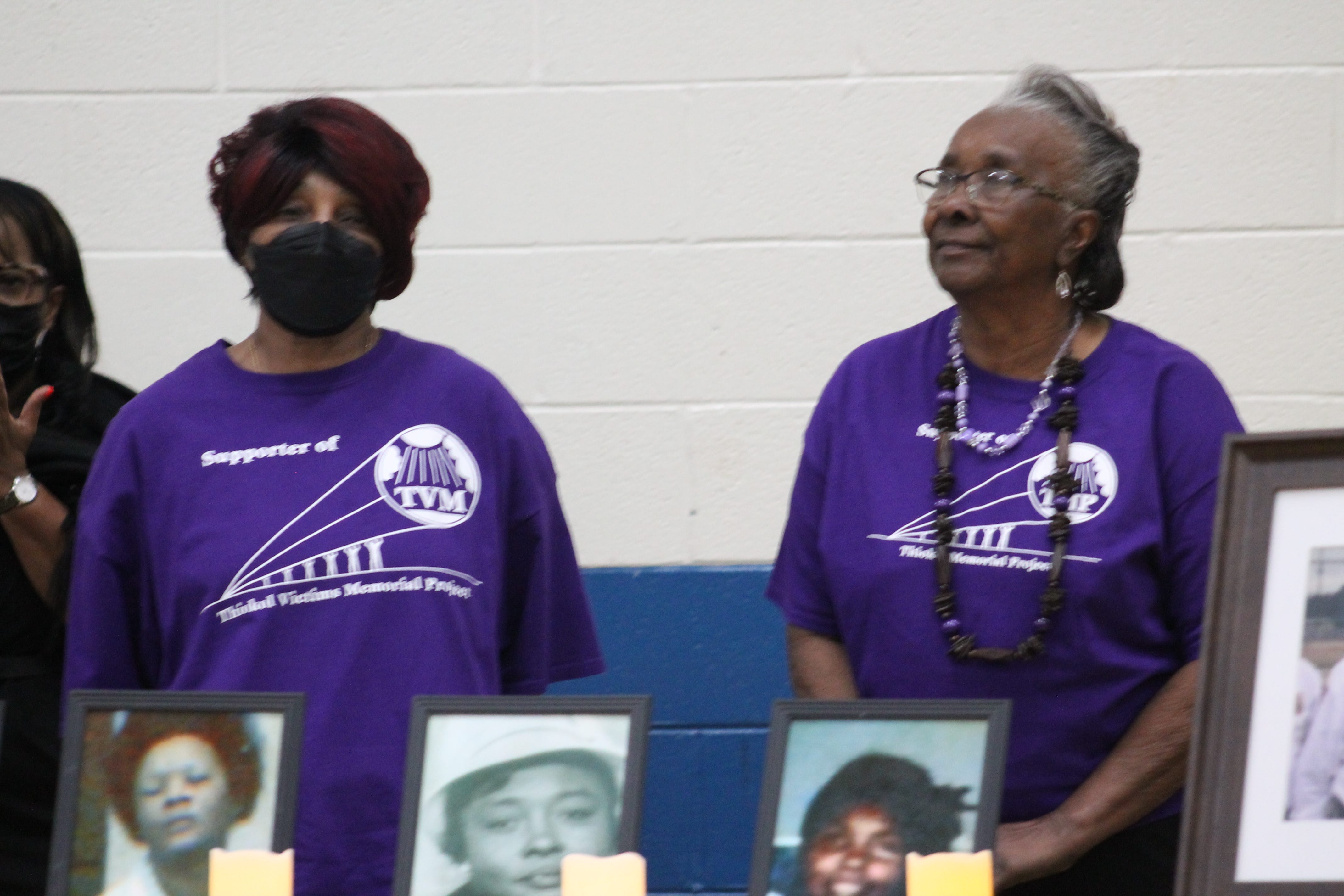 Survivors of the Feb. 3, 1971, explosion at the Thiokol plant in Woodbine, Georgia, stand behind the pictures of the victims of the tragedy at the 52nd commemoration ceremony for the Thiokol plant explosion in Woodbine on Feb. 3, 2023.