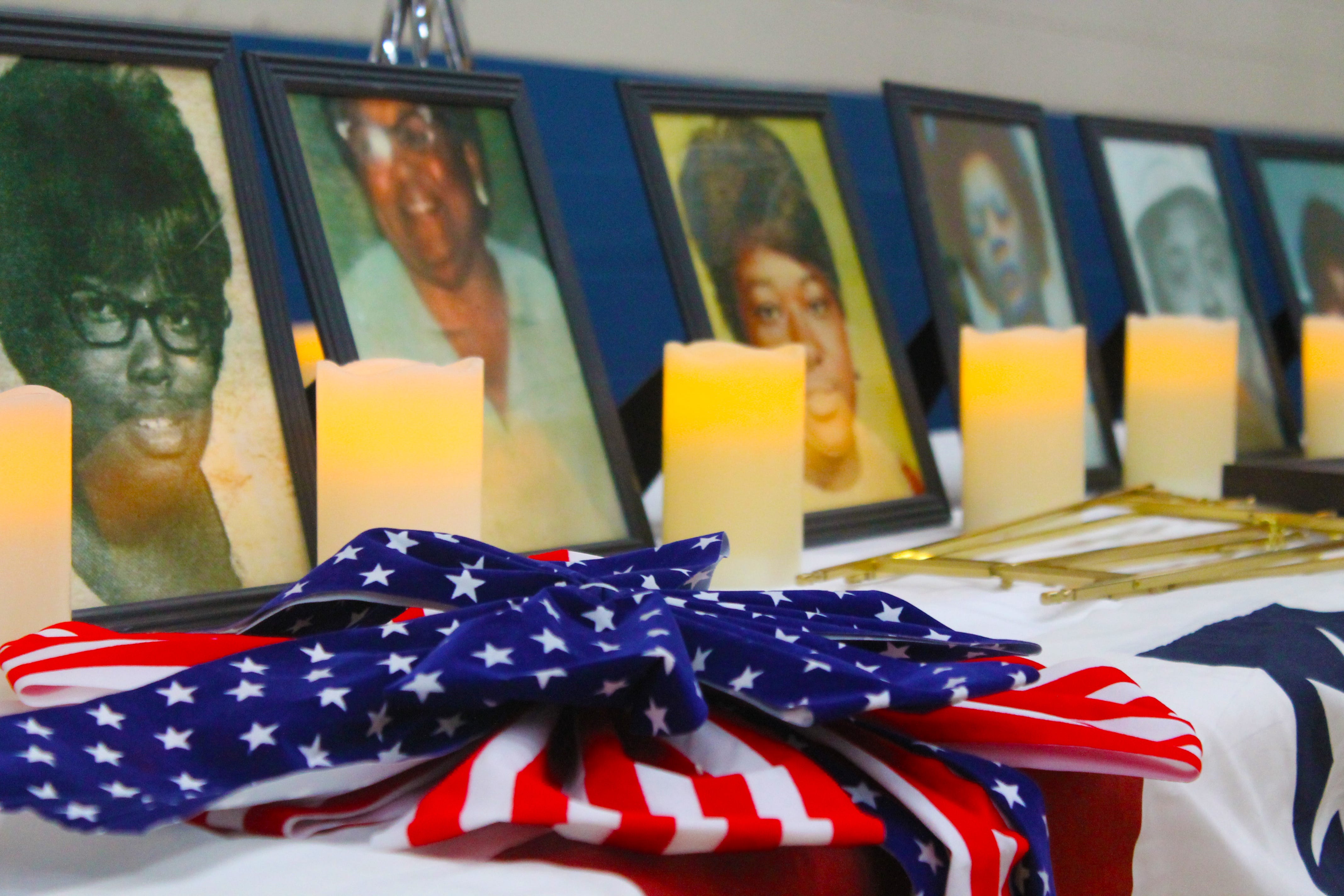 A U.S.A. banner sits alongside candles pictures of the victims of the Feb. 3 tragedy at the Thiokol plant in Woodbine.