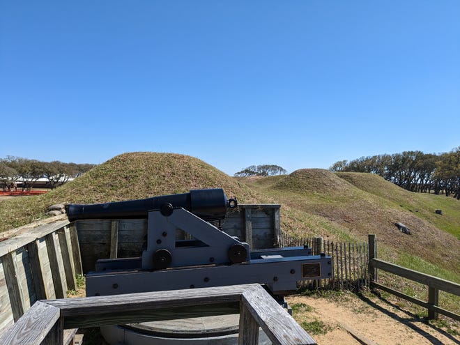 An earthwork defense at Fort Fisher with a replica cannon. State funds could be used to restore more of the Civil War fort's defensive mounds.