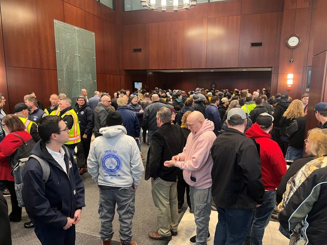 Orang-orang memenuhi lobi gedung kantor Senat Michigan pada Selasa pagi di pusat kota Lansing untuk sidang komite tentang pencabutan undang-undang hak kerja negara bagian.