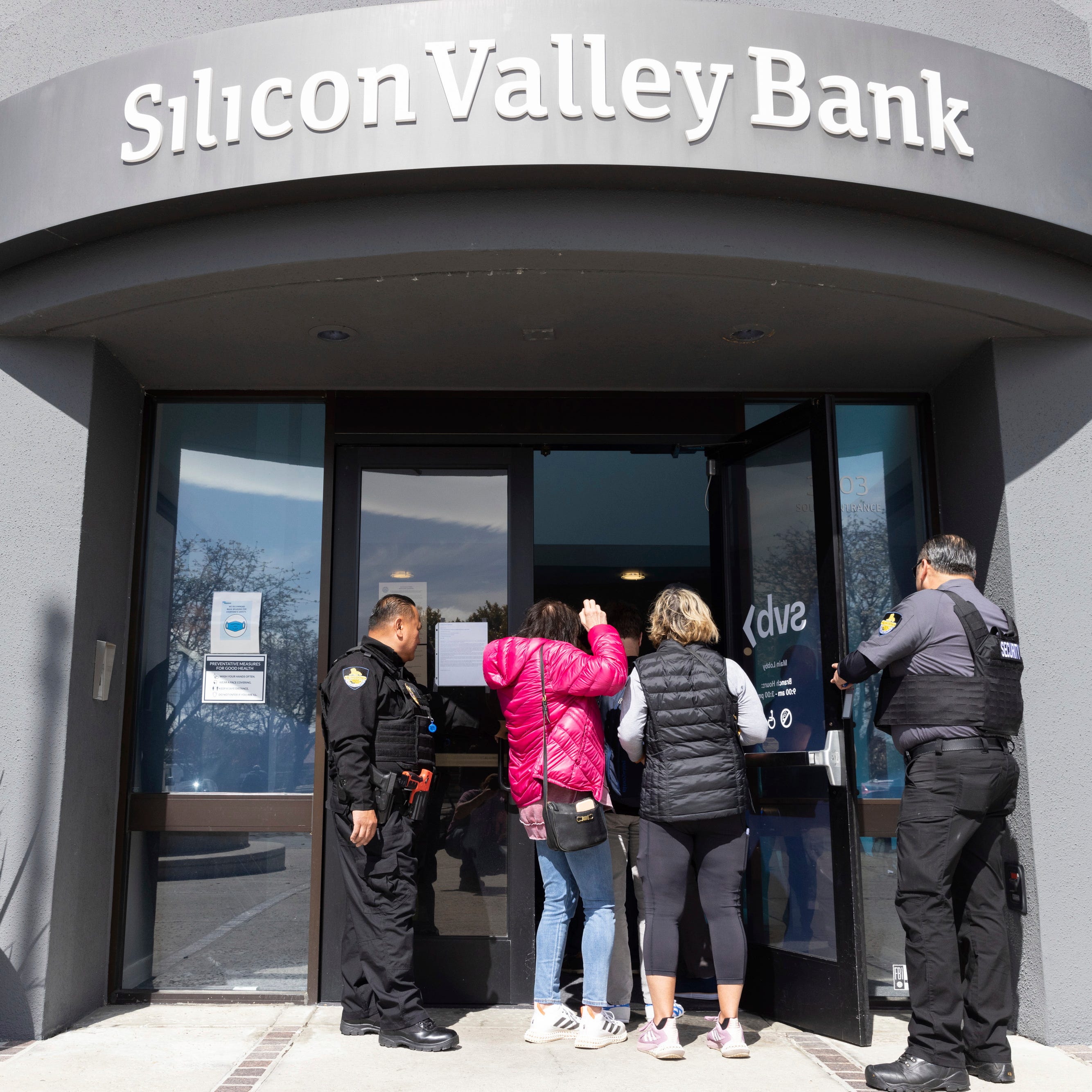 Security guards let individuals enter the Silicon Valley Bank's headquarters in Santa Clara, Calif., on March 13, 2023. The Federal Deposit Insurance Corporation has taken over the bank after failed attempts to sell it to healthier banks.