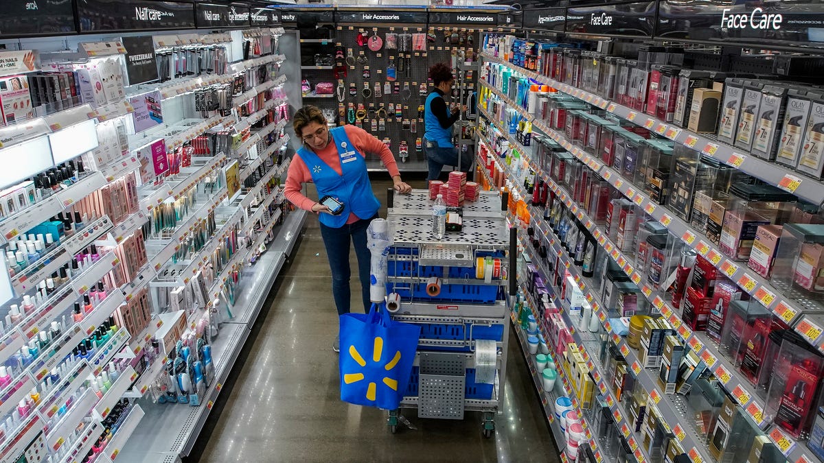 An employee organizes beauty products inside the Walmart Supercenter in North Bergen, N.J. on Thursday, Feb. 9, 2023. A strong job market has helped fuel the inflation pressures that have led the Federal Reserve to keep raising interest rates.