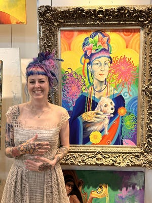 Megan Howell, Second Heart Homes founder and executive director, stands in front of an original painting of her by local artist Mary Sencabaugh at the nonprofit's annual art auction.