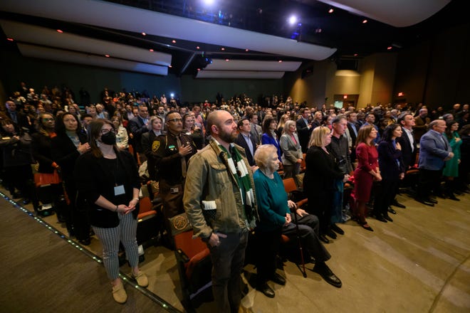 Penonton berdiri untuk lagu kebangsaan sebelum dimulainya pidato Negara Bagian Oakland County dari Eksekutif David Coulter di dalam Berman Center for Performing Arts, di West Bloomfield, 14 Maret 2023.