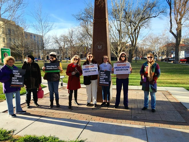 Protesters stand outside the Mary Lou Robinson United States Courthouse ahead of a public hearing in a lawsuit against the abortion medication mifepristone on March 15, 2023.