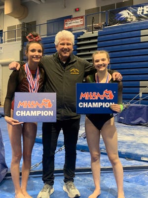 Grand Ledge coach Duane Haring, center, is pictured with senior Alaina Yaney, left, and junior Lydia Beaton, right. Yaney was the all-around state champion in Division 1 and Beaton won the title in Division 2 at the MHSAA state finals.