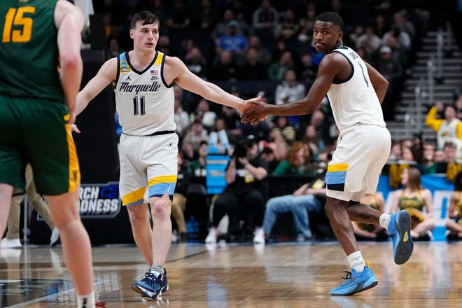 Marquette guard Tyler Kolek high-fives teammate Kam Jones after Jones hit a 3-pointer against Vermont on Friday. Jones scored 18 straight points for the Golden Eagles in the second half. Kolek was the Big East player of the year.