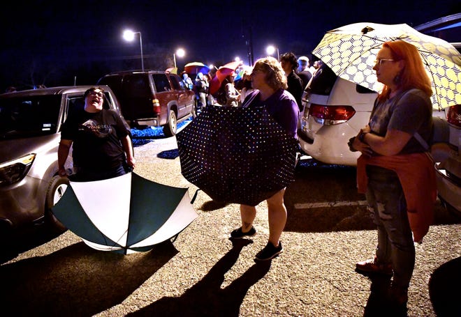 Women with umbrellas form a barrier at the entrance of the Abilene Community Theater auditorium on March 11.  After a controversy over a drag show that was scheduled to be performed that night, attendees cordoned off an area for their safety.
