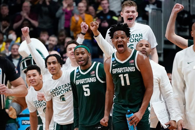 Michigan State players including Tre Holloman (5) and A.J. Hoggard (11) celebrate on the bench during their second-round win over Marquette in the NCAA men's basketball tournament.
