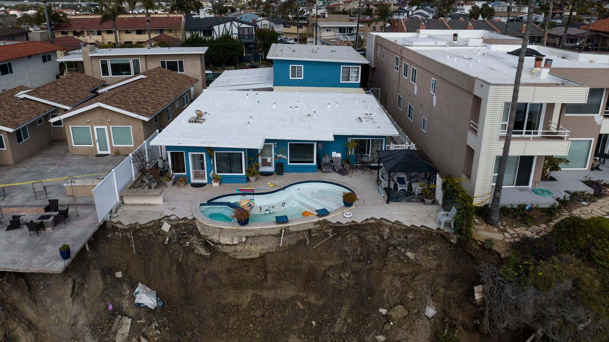 In this image taken with a drone, a residential swimming pool hangs on a cliffside after a landslide occurred in San Clemente, Calif., Thursday, March 16, 2023.