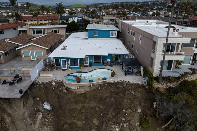 In this image taken with a drone, a residential swimming pool hangs on a cliffside after a landslide occurred in San Clemente, Calif., on March 16, 2023.