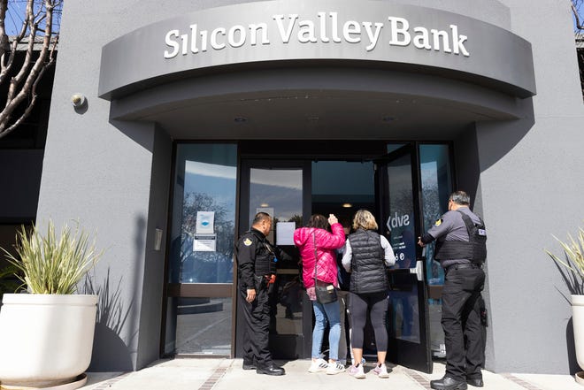 Security guards allow individuals to enter Silicon Valley Bank's headquarters in Santa Clara, California, on March 13.