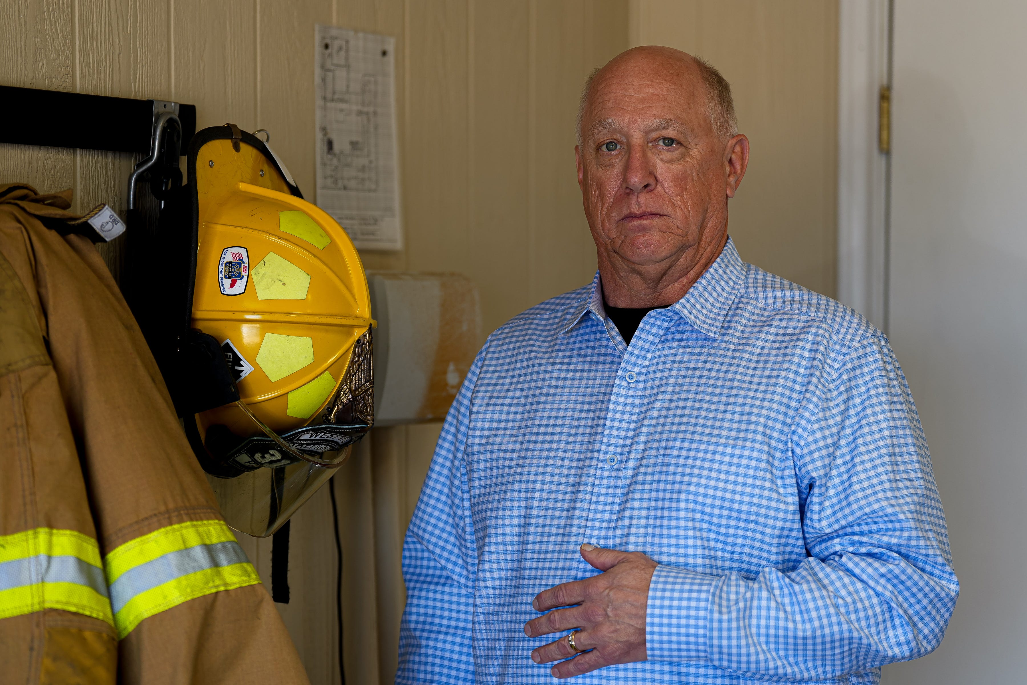 Robert Payne, a firefighter with the West Volunteer Fire Dept., in February 2023. He keeps a jacket and helmet on the wall of his garage.