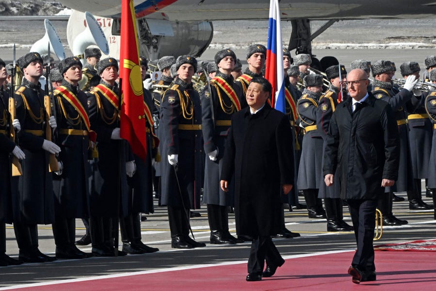 China's President Xi Jinping, accompanied by Russian Deputy Prime Minister Dmitry Chernyshenko, walks past guards during a welcoming ceremony at Moscow's Vnukovo airport on March 20, 2023.