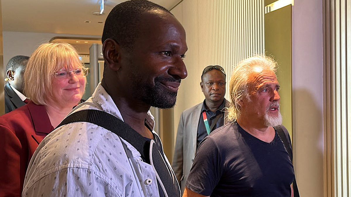 French journalist Olivier Dubois (3rd L), freed nearly two years after he was kidnapped by the Support Group for Islam and Muslims (GSIM) in Mali, and US national Jeffery Woodke (R), freed after being kidnapped in October 2016 in Niger, are seen as they arrive at the Diori Hamani International Airport in Niamey on March 20, 2023.