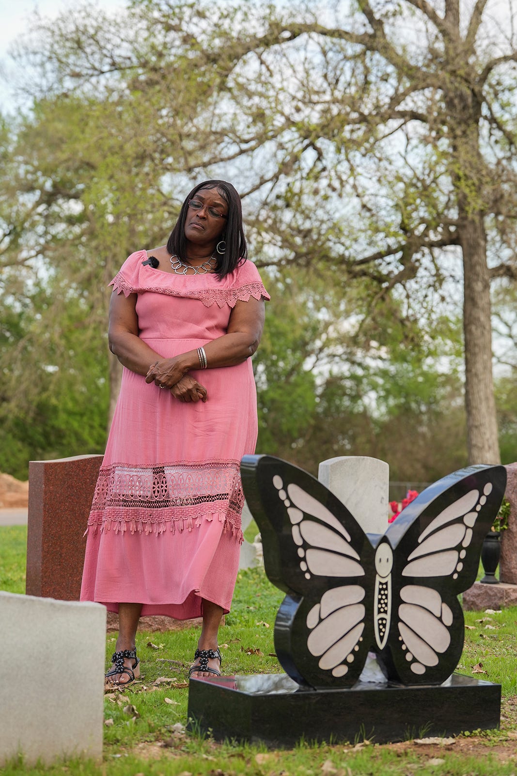 Carolyn White-Mosley stands beside the butterfly-shaped headstone marking the grave of her younger daughter, Ortralla Mosley. Butterflies had special meaning for Ortralla, proof that anyone could change into something beautiful.