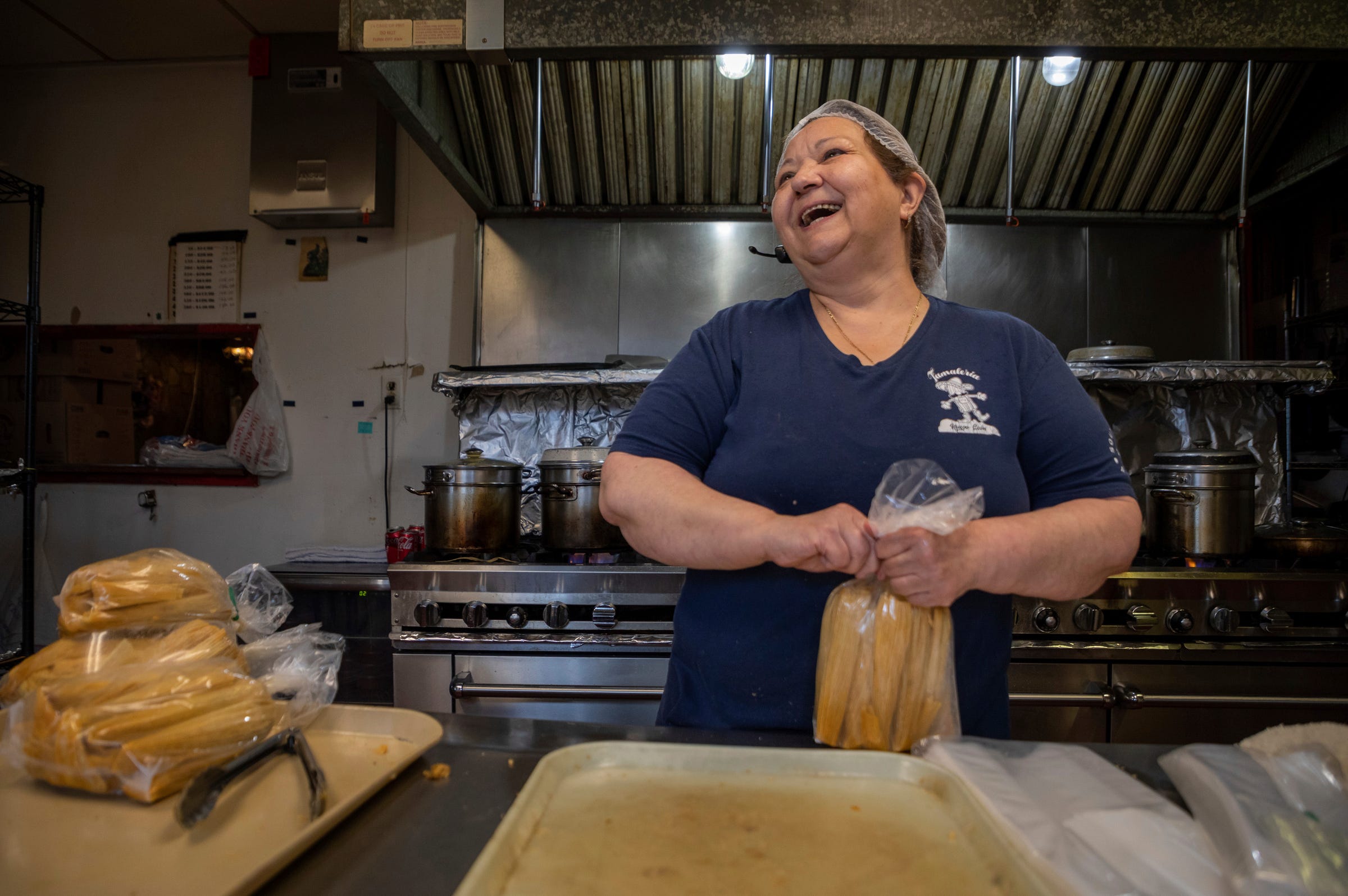 Susana "Suzy" Villarreal-Garza, the owner of Tamaleria Nuevo Leon in Detroit's Mexicantown, laughs as she ties a bag full of tamales inside her business in southwest Detroit on Thursday, March 2, 2023. 