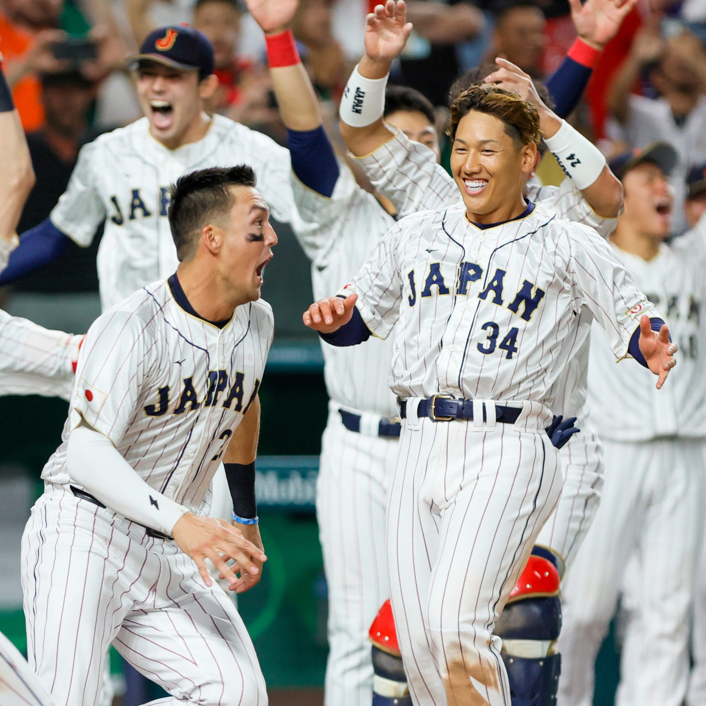 Japan players celebrate after winning the World Baseball semifinal game against Mexico at LoanDepot Park.