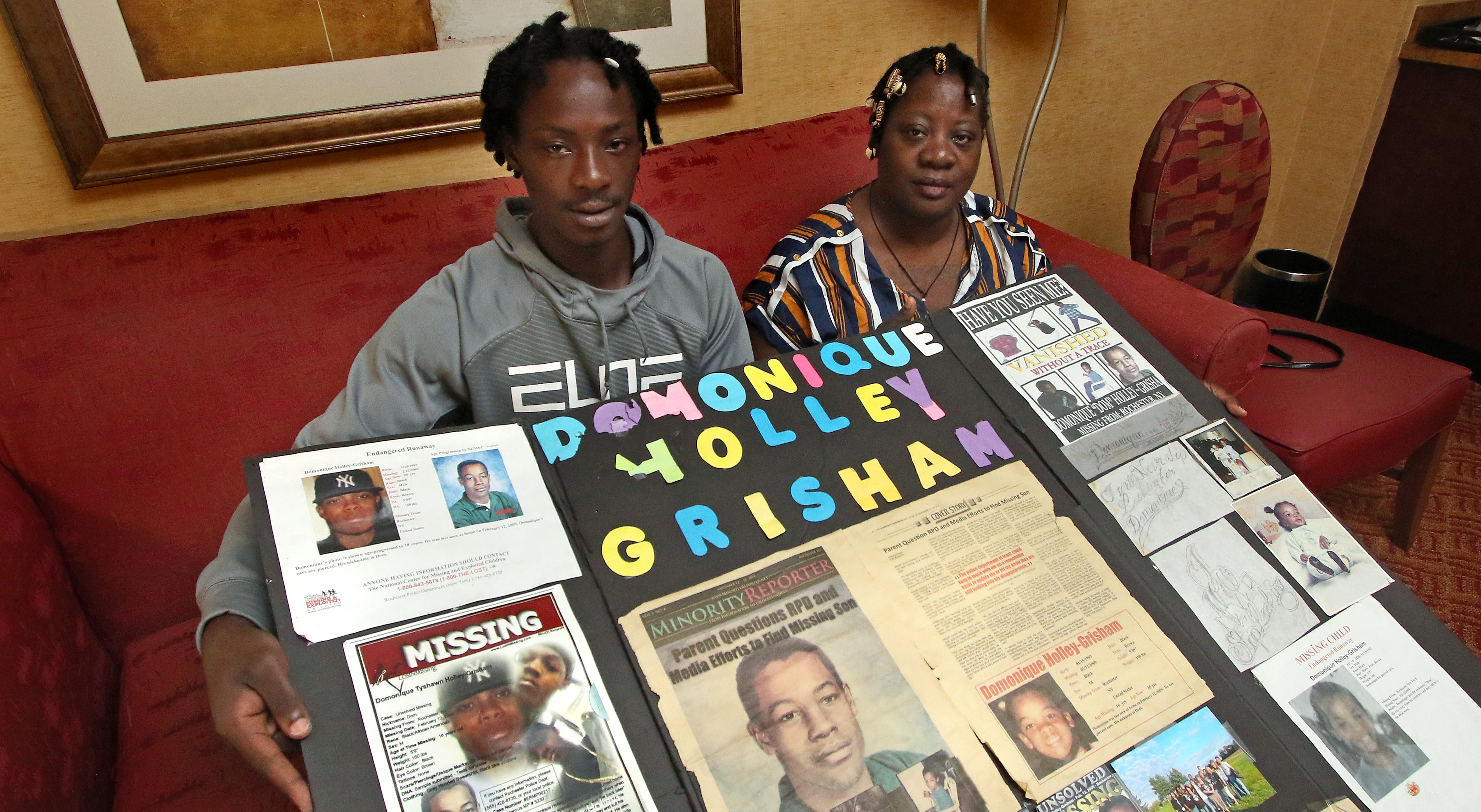 Jaquan Holley-Grisham and his mother, Mozell Jones-Grisham, with a poster of Domonique Holley-Grisham, who disappeared in 2009 at 16.
