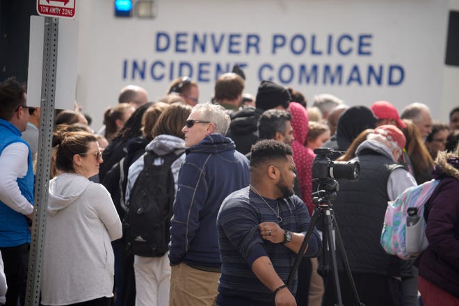 Los padres esperan que los estudiantes salgan después de que dos administradores dispararon y resultaron heridos después de que se encontrara una pistola durante una búsqueda diaria de un estudiante en la Escuela Secundaria Denver East el miércoles 22 de marzo de 2023, en Denver.