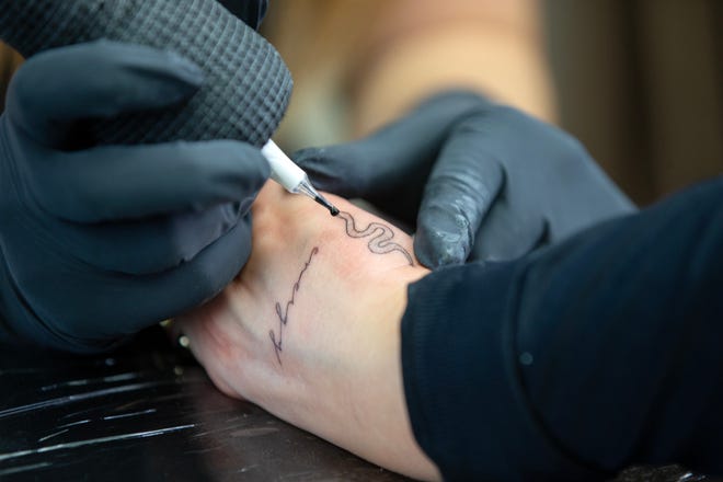 Sydney Smith, owner of Blxck Rose Ink, a Point Pleasant tattoo shop which opened in September 2020, touches up a tattoo on the hand of Victoria Demko of Shelton, Connecticut at Blxck Rose Ink in Point Pleasant, NJ Friday March 24, 2023.  