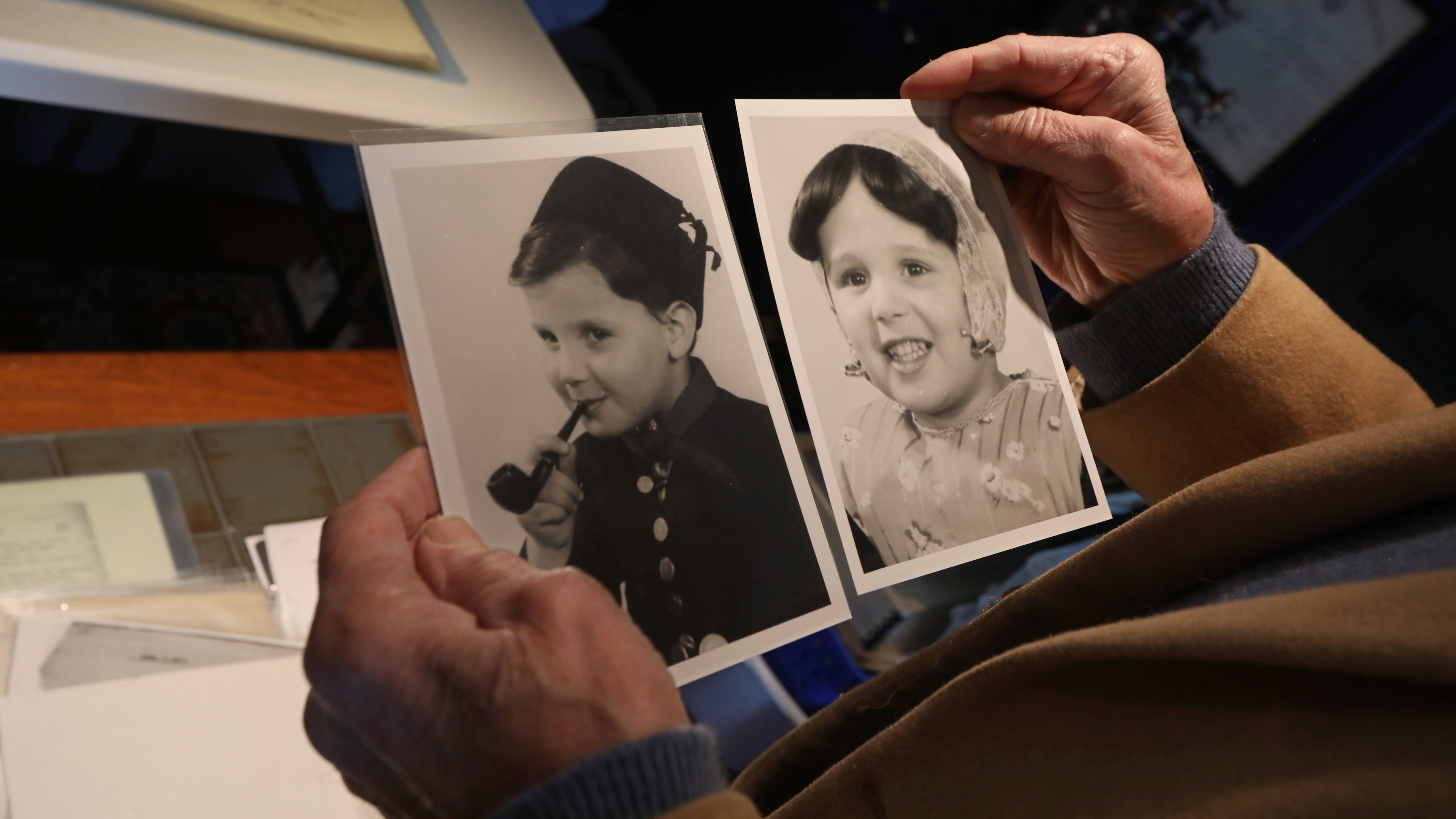 Steven Hess holds a photo of himself and his twin sister Marion Ein Lewin, dressed in traditional Dutch costumes that was taken about a year before they were deported to the Westerbork and Bergen-Belsen Concentration Camps in 1944.